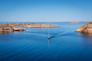 A,Lone,Sailboat,On,Its,Way,Between,The,Cliffs,Of